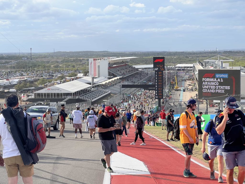 A view from the apex of Turn 1 at COTA, looking down towards thousands of fans on the pit straight
