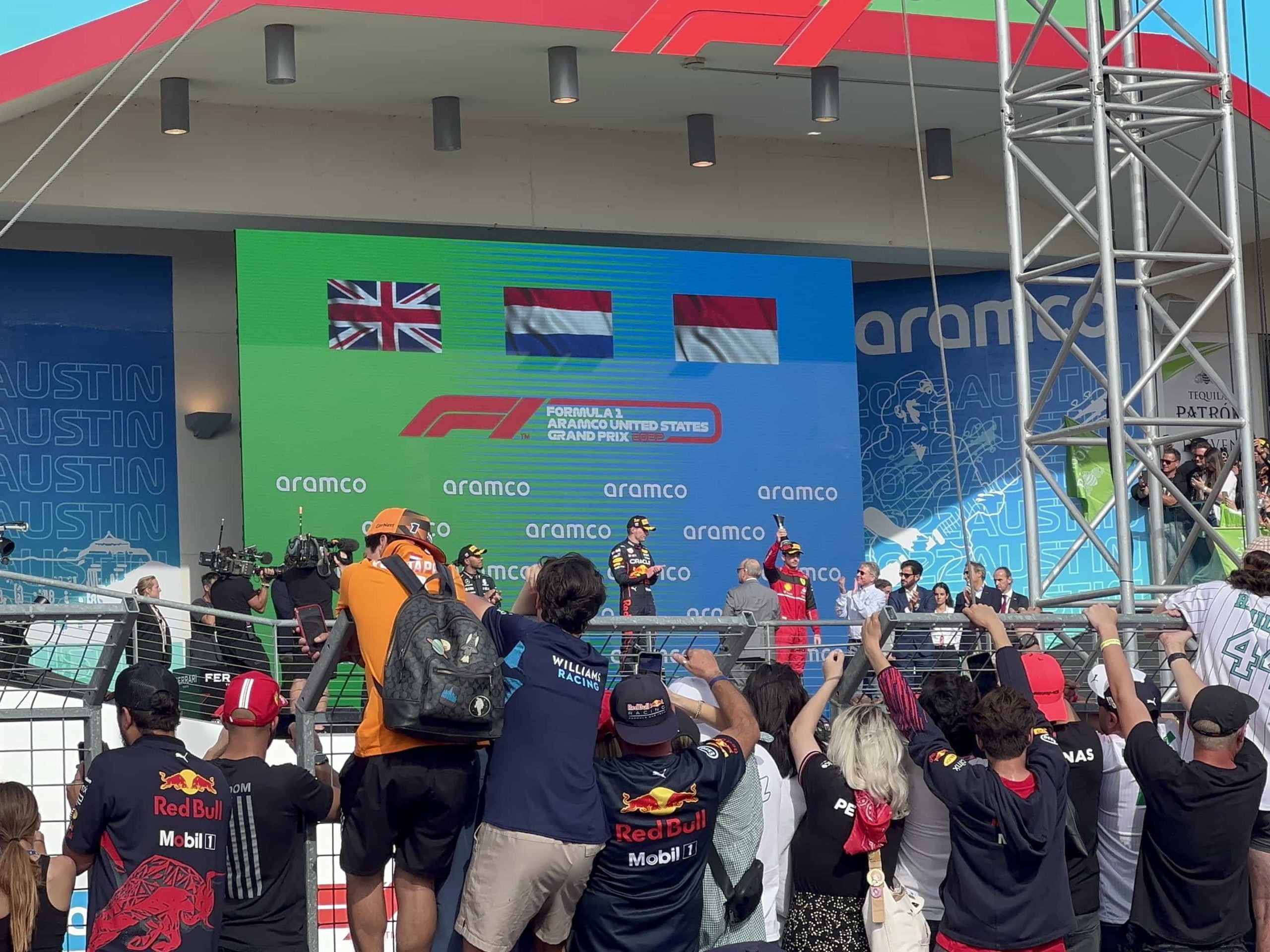 Verstappen, Hamilton, and Leclerc atop the podium, during post-race celebrations