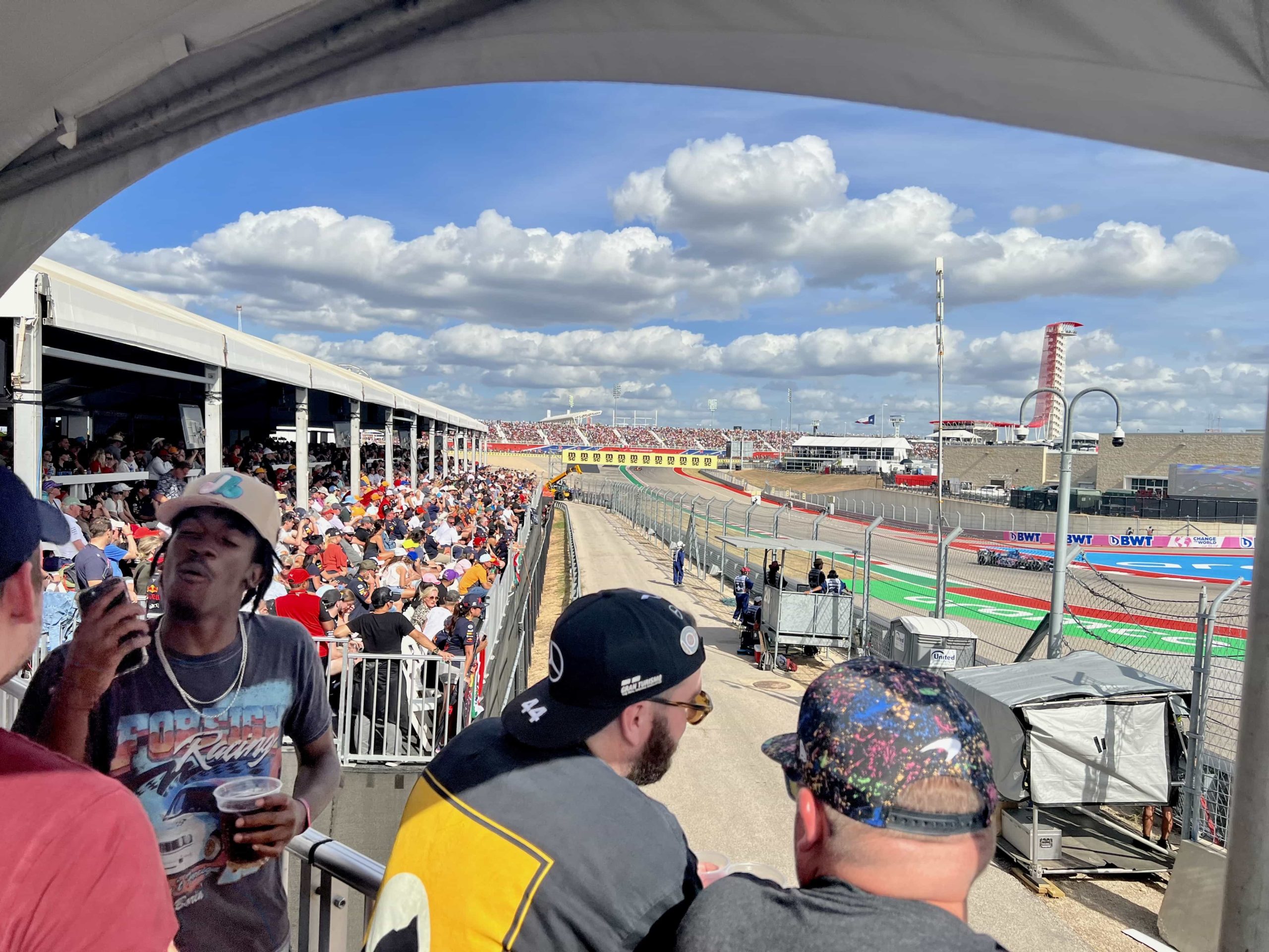 A grandstand of spectators (in the Podium Club) wraps around the final corner at COTA