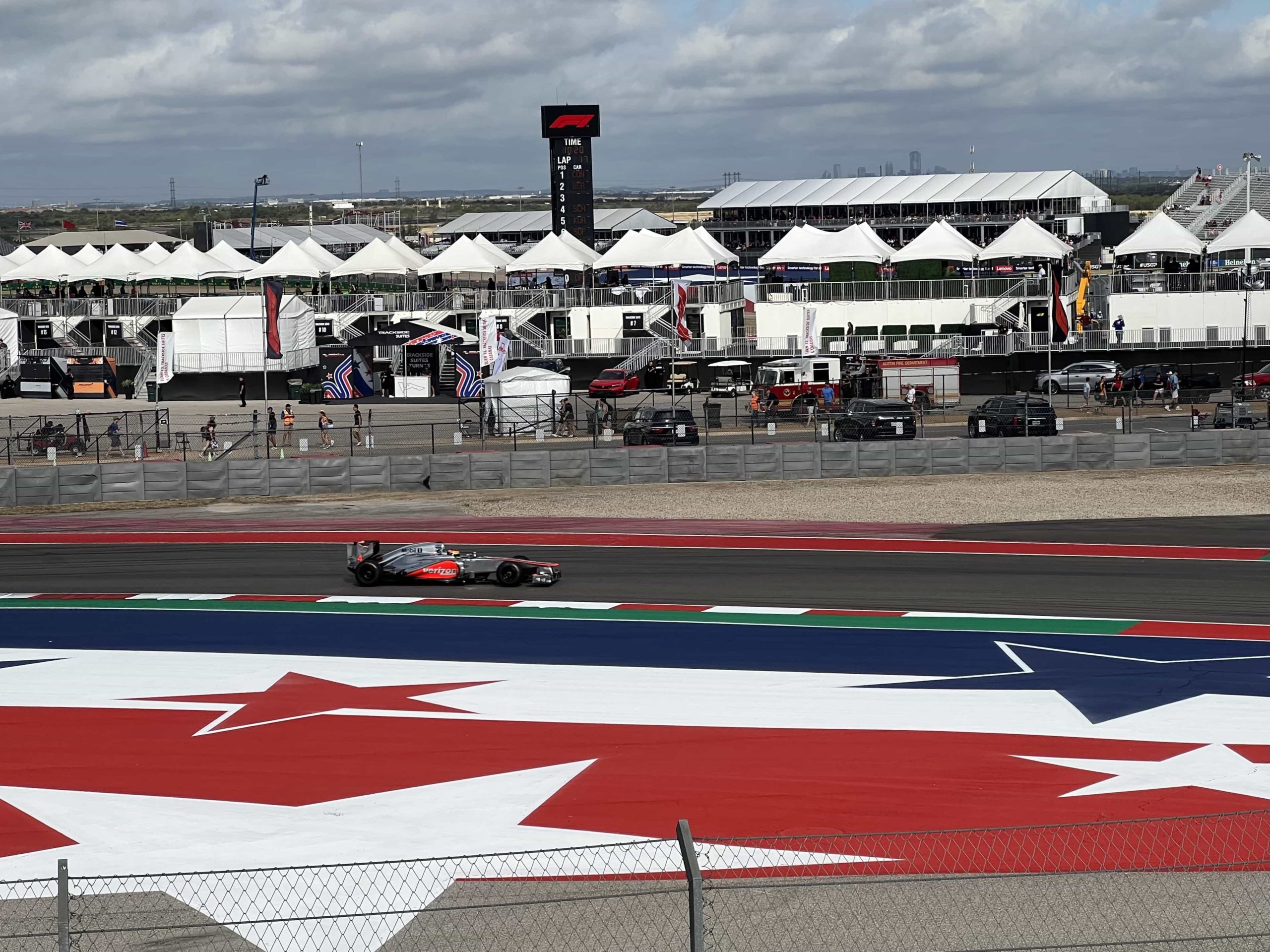 A McLaren MP4-27 in a silver and red Verizon livery on track at COTA