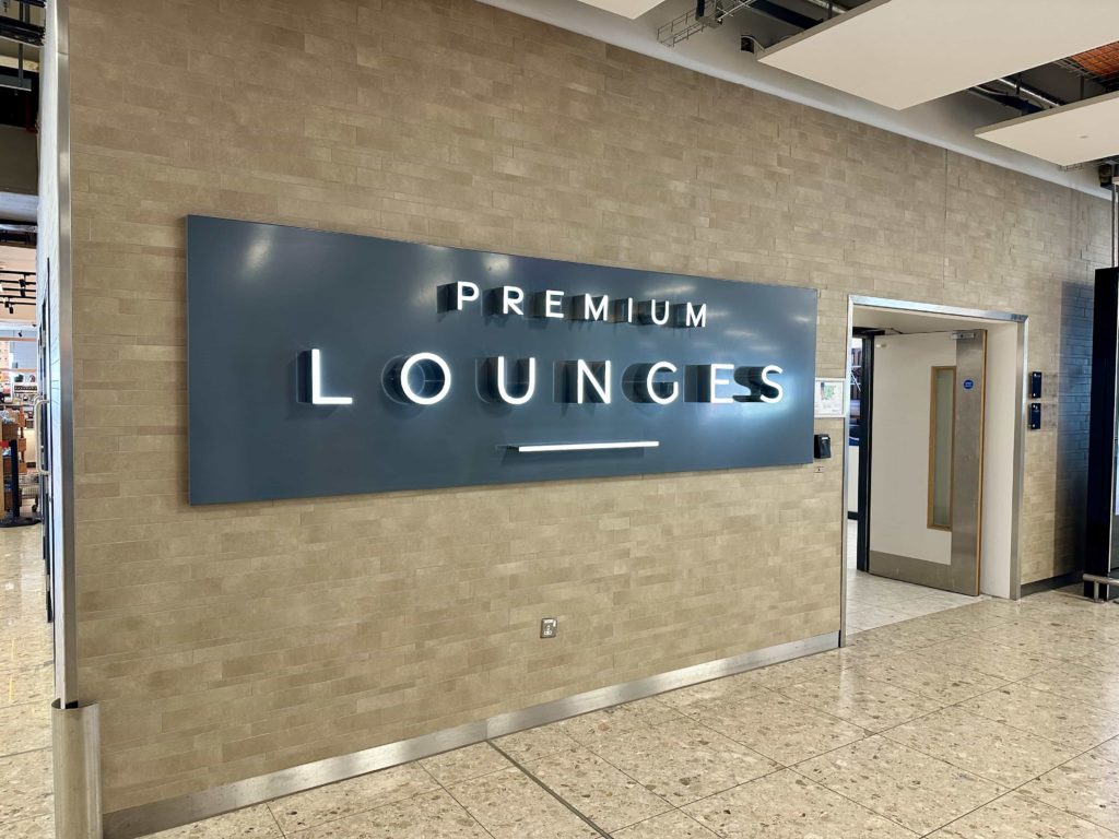 A large 'Premium Lounges' sign, adjacent to a stairwell which leads  to the Aspire and Premium Plaza lounges