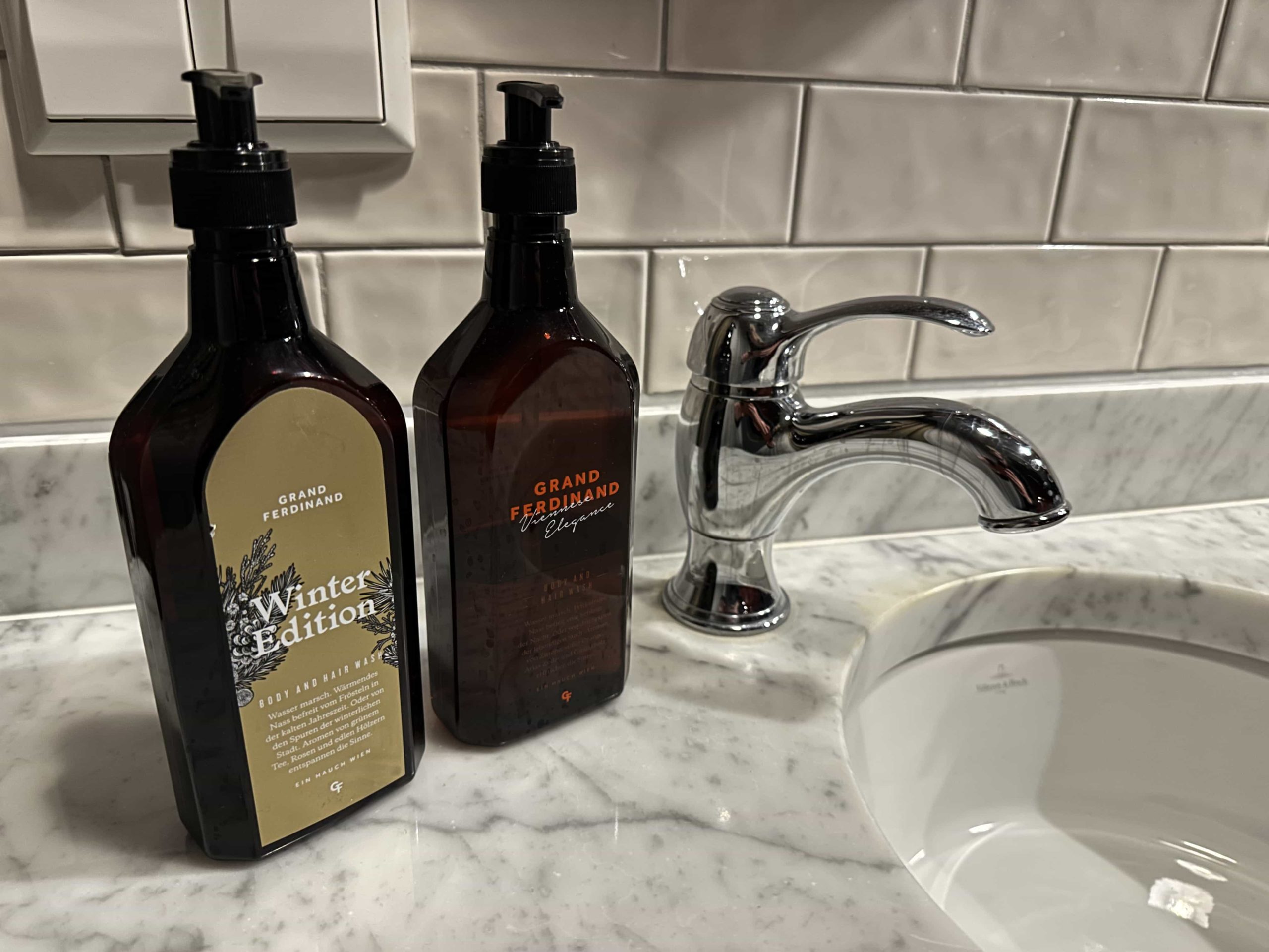 Two bottles of hand wash, with Grand Ferdinand branding, next to a sink