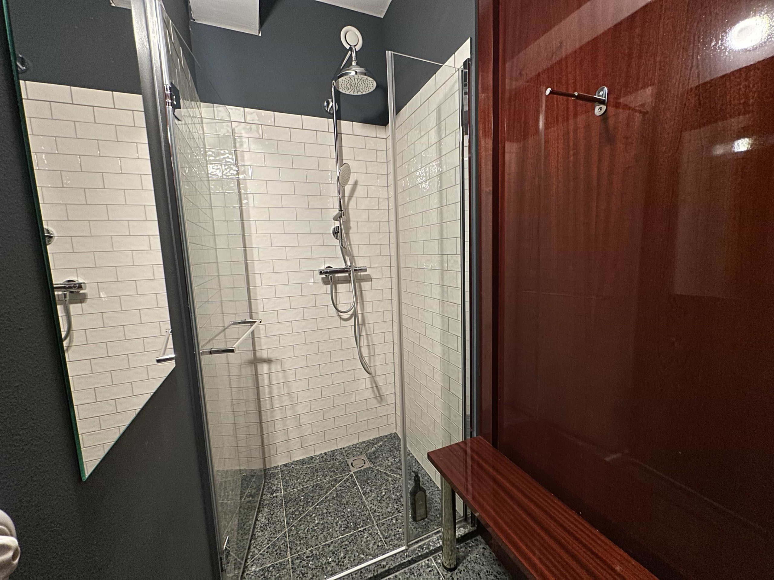 A shower room, with a changing area in front of the walk-in shower cubicle