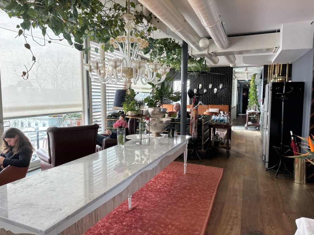 An eclectic mix of decor in a casual seating area of a rooftop restaurant in a hotel