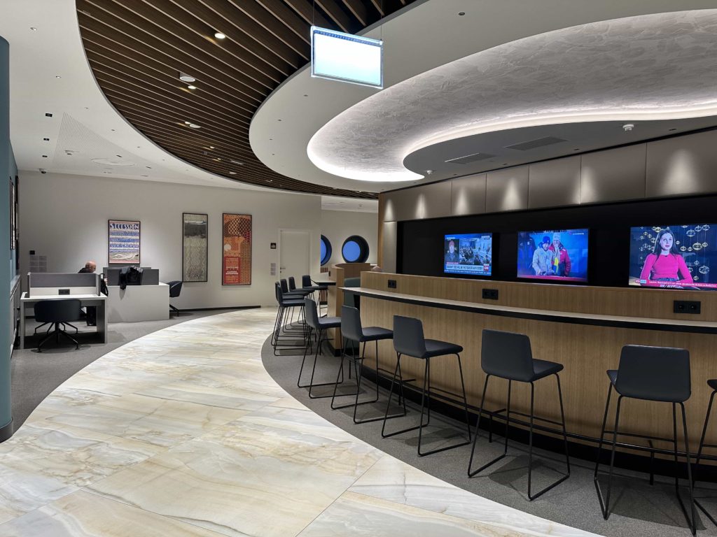 A workspace area, with barstool seats, overlooking a TV area