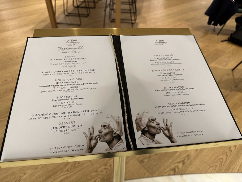 A menu atop a podium, listing the food options available to airport lounge customers