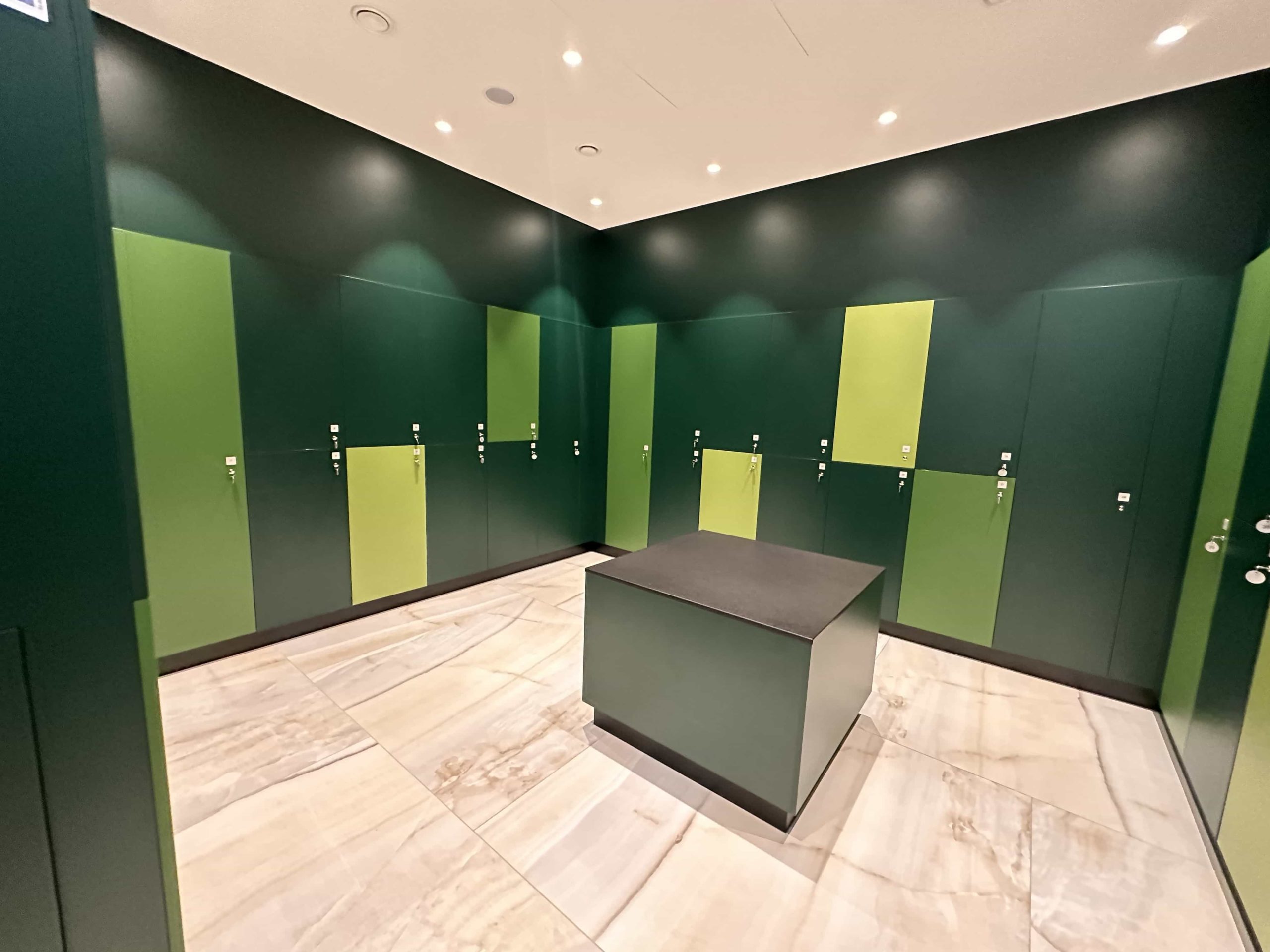 A square room of lockers, in various shades of green