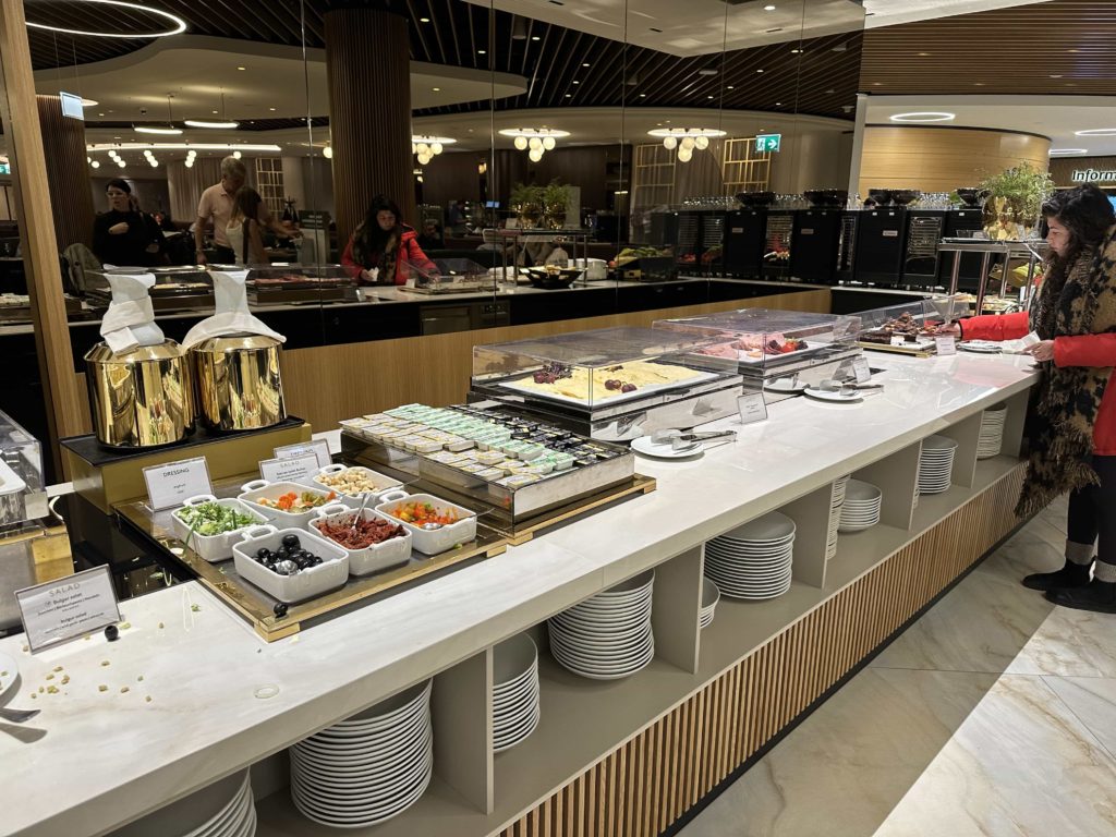 A selection of salad items, cold cut meats, and cheeses, as part of a buffet selection