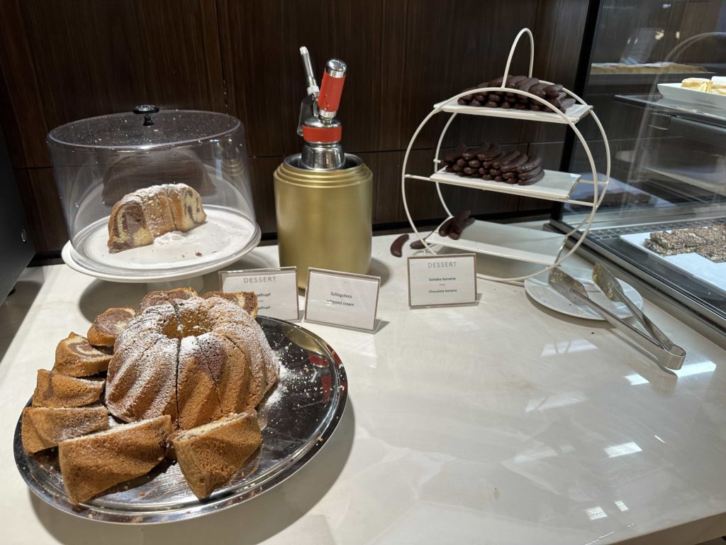 A selection of desserts atop a counter, and a whipped cream dispenser