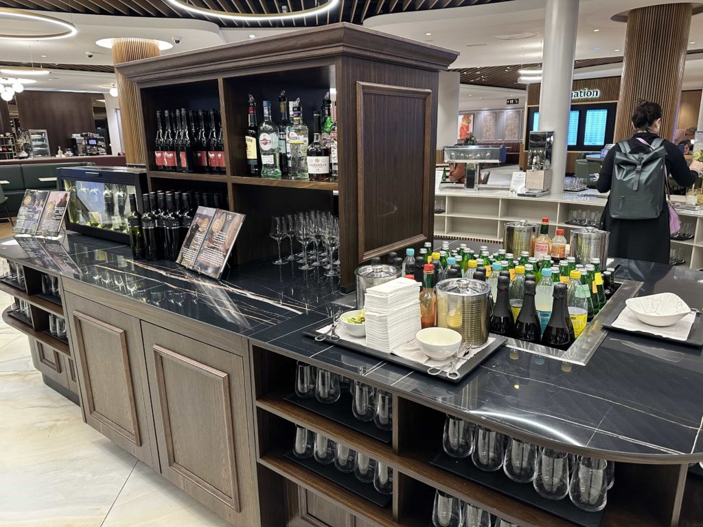 A self-serve bar area with a range of soft drinks, alcohol, and glassware