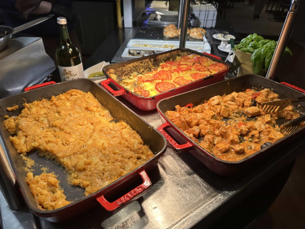 Three Mediterranean-inspired baked dishes at a hotel buffet