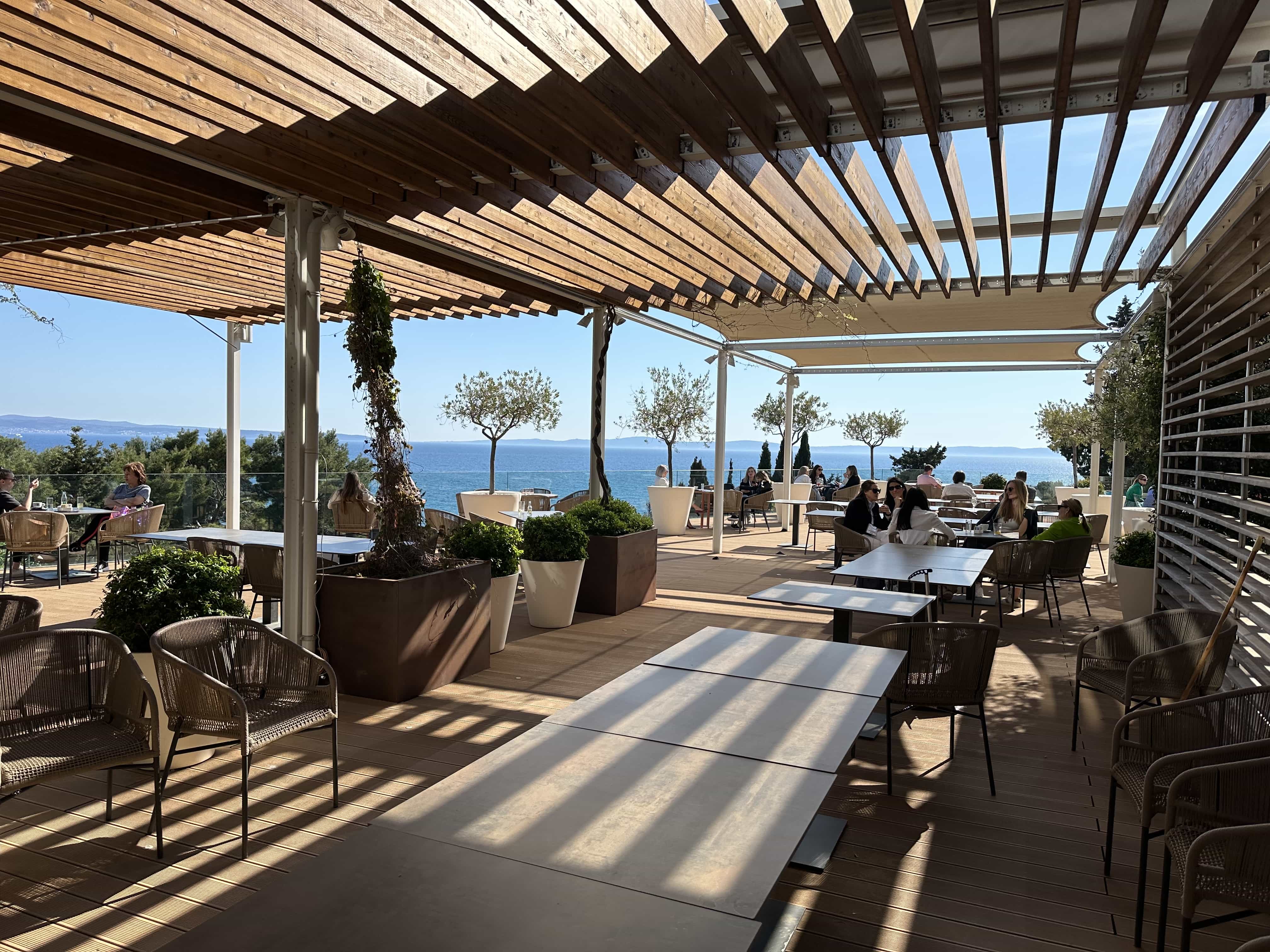 A restaurant setup in a shaded outdoor terrace