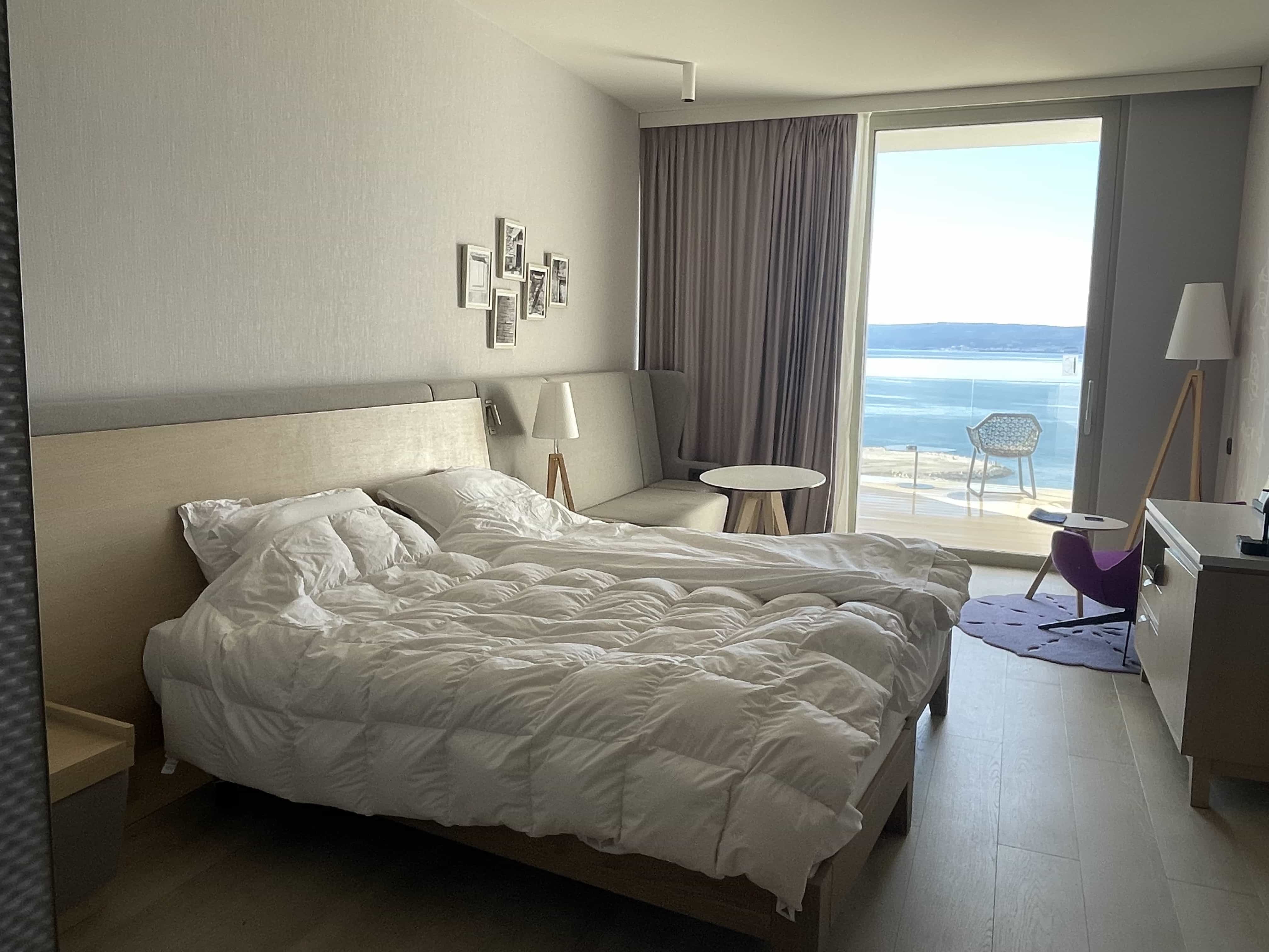 Two twin beds in a hotel room, with views out towards the sea