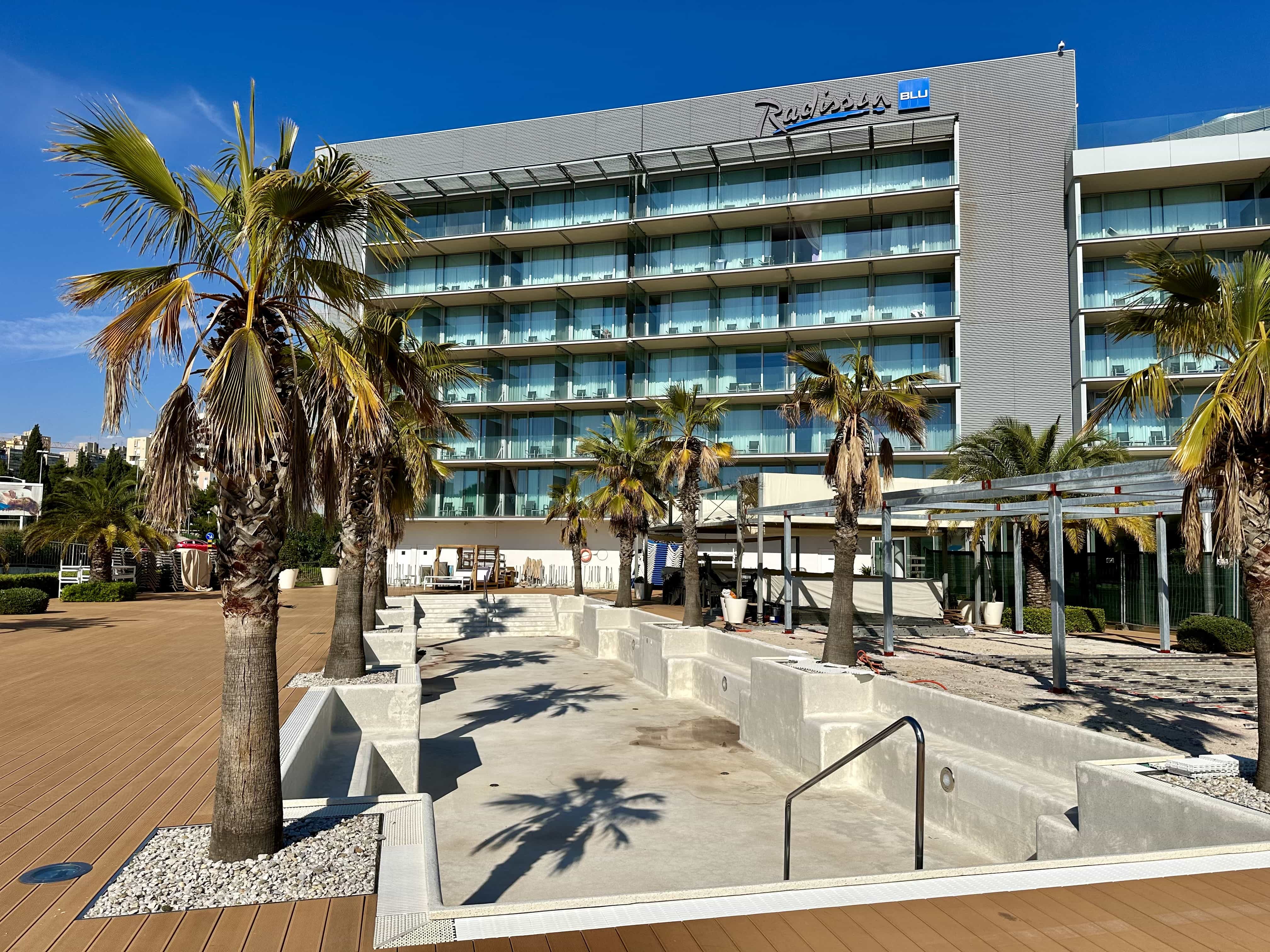 An exterior view of the Radisson Blu, Split hotel, with an empty pool in the foreground