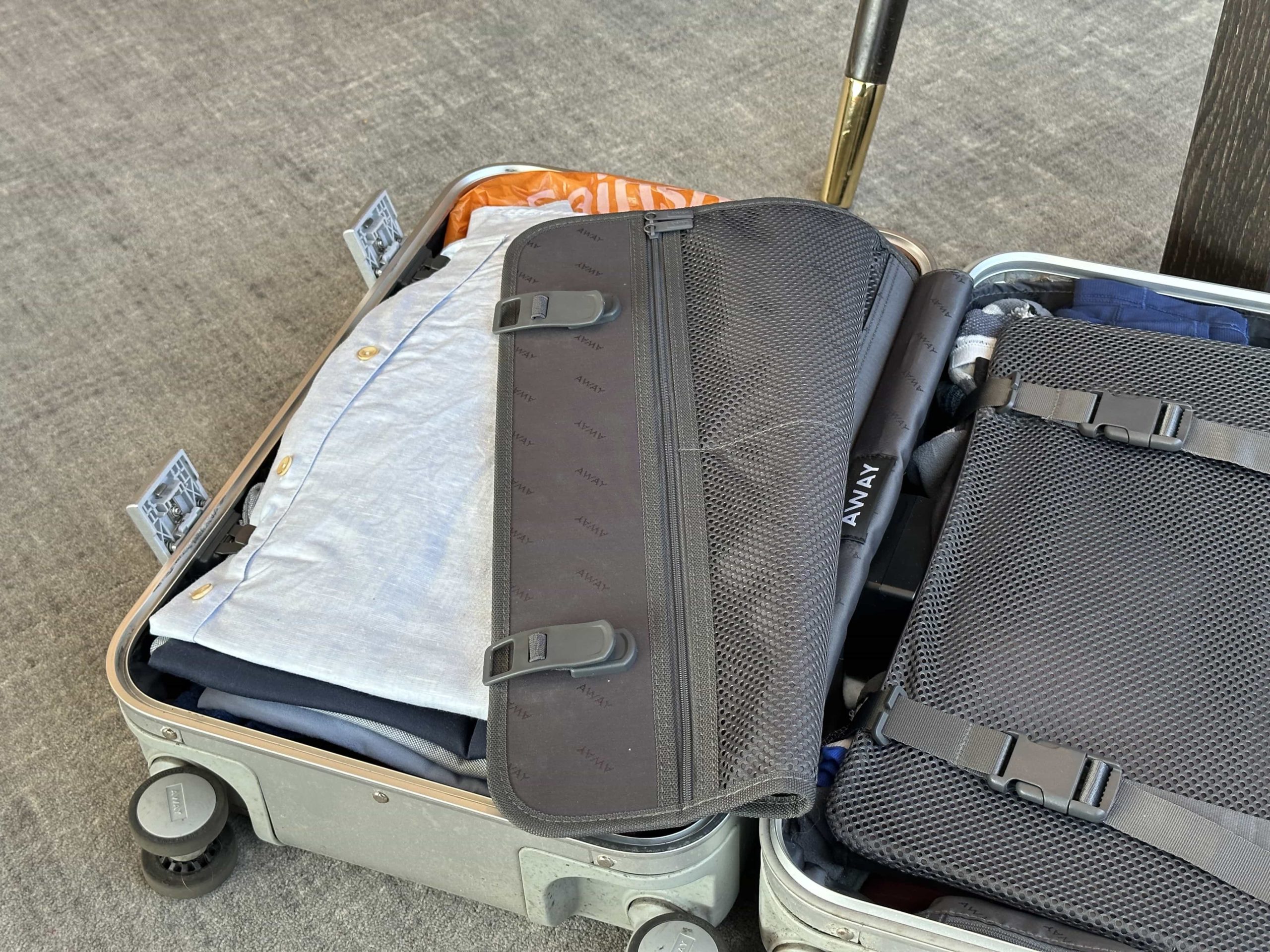 An open suitcase with clothes packed neatly in one side