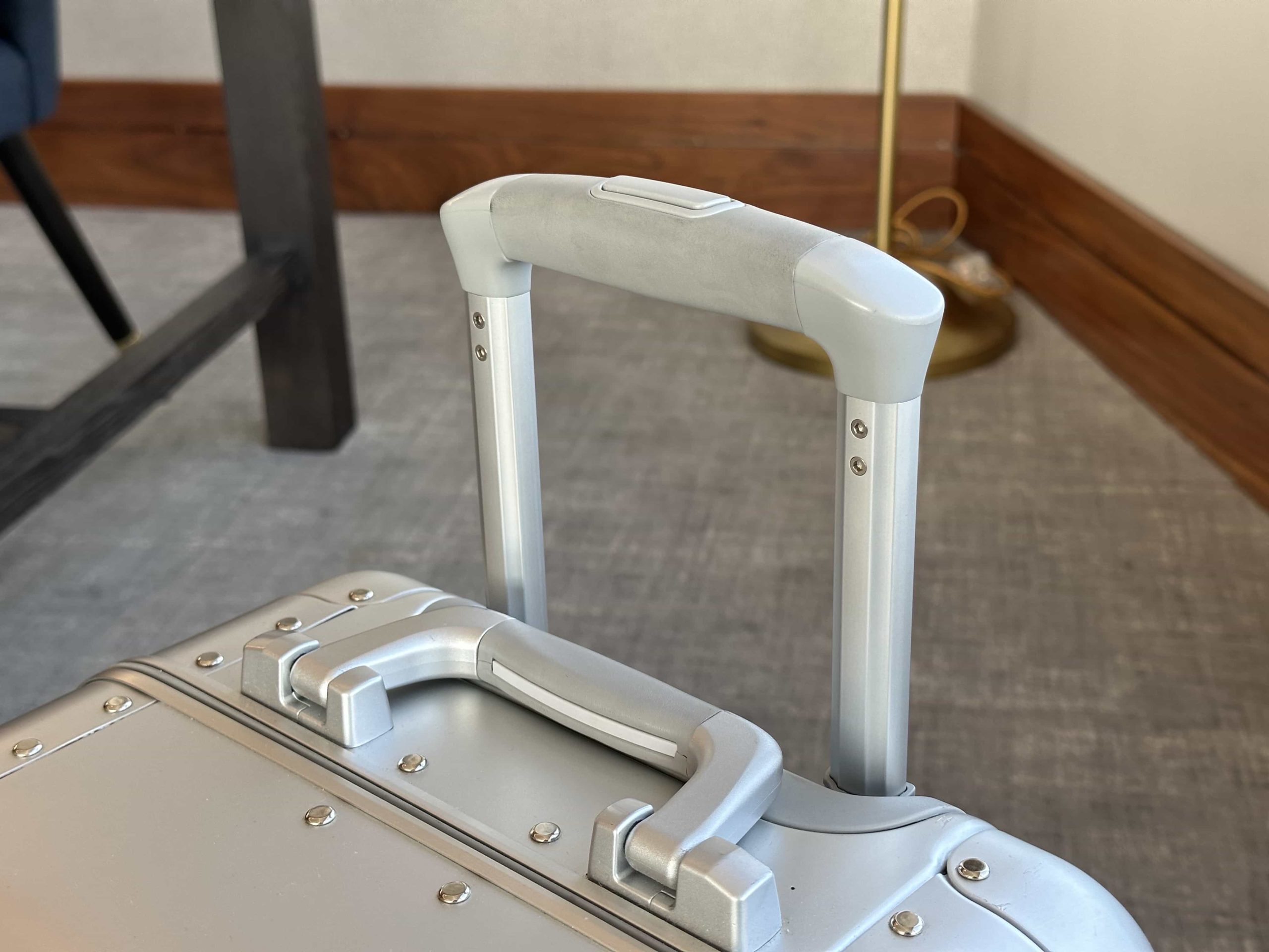 A telescoping handle on a suitcase slightly extended