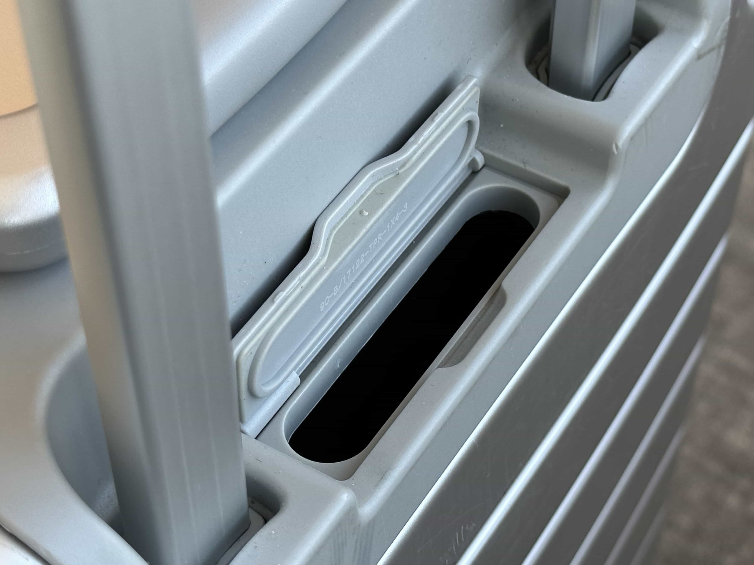 An open portable battery compartment door on a suitcase