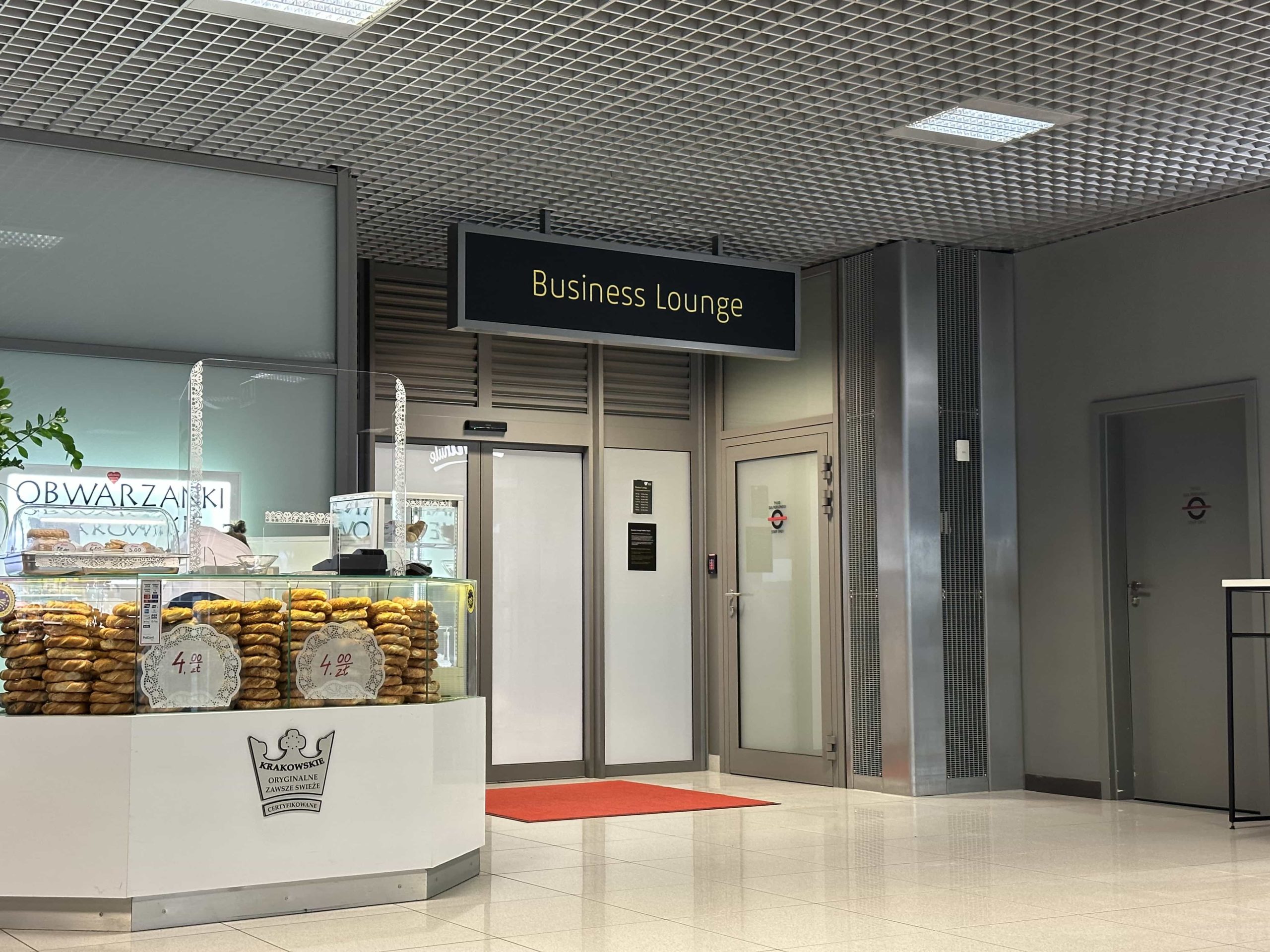 An unassuming entrance to a business lounge, in a corner next to a food stall