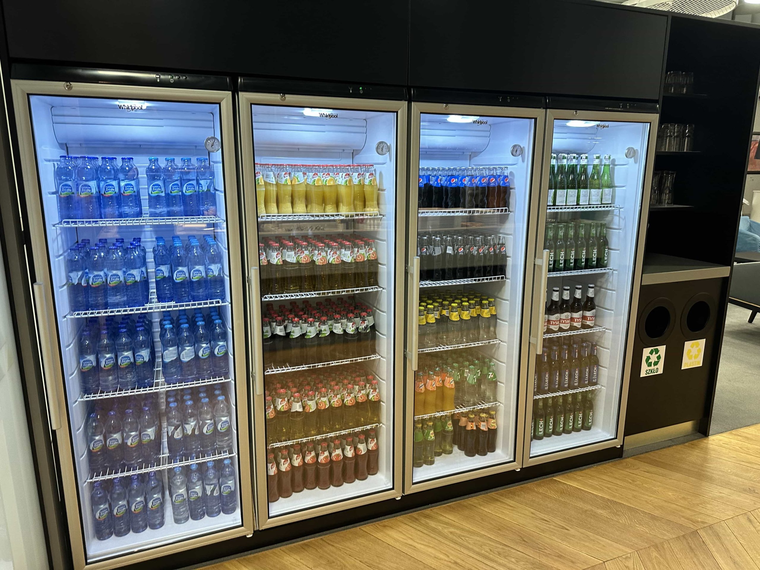 Four large fridges with an assortment of soft drinks