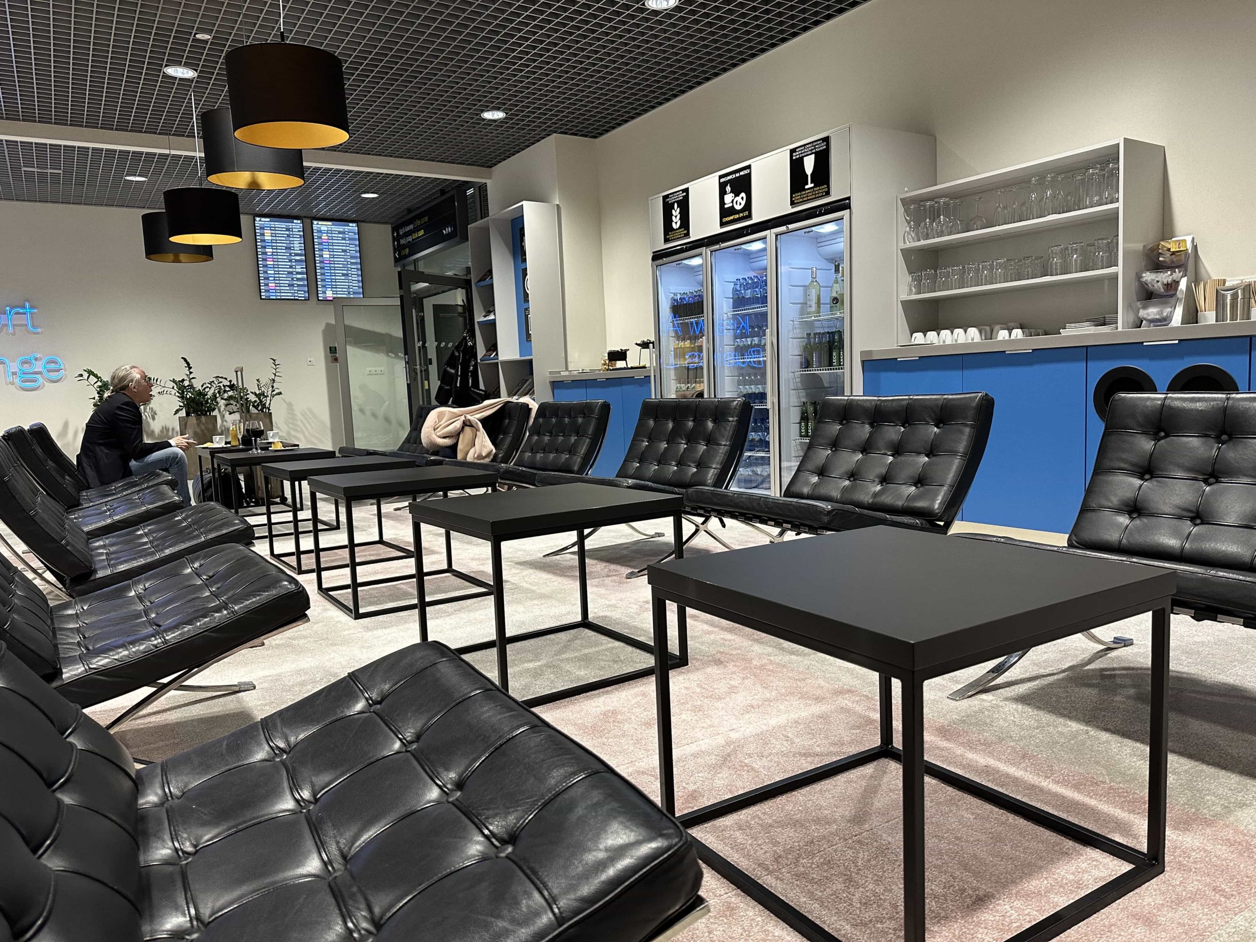 Rows of lounge chairs in a brightly lit room with snacks and drinks