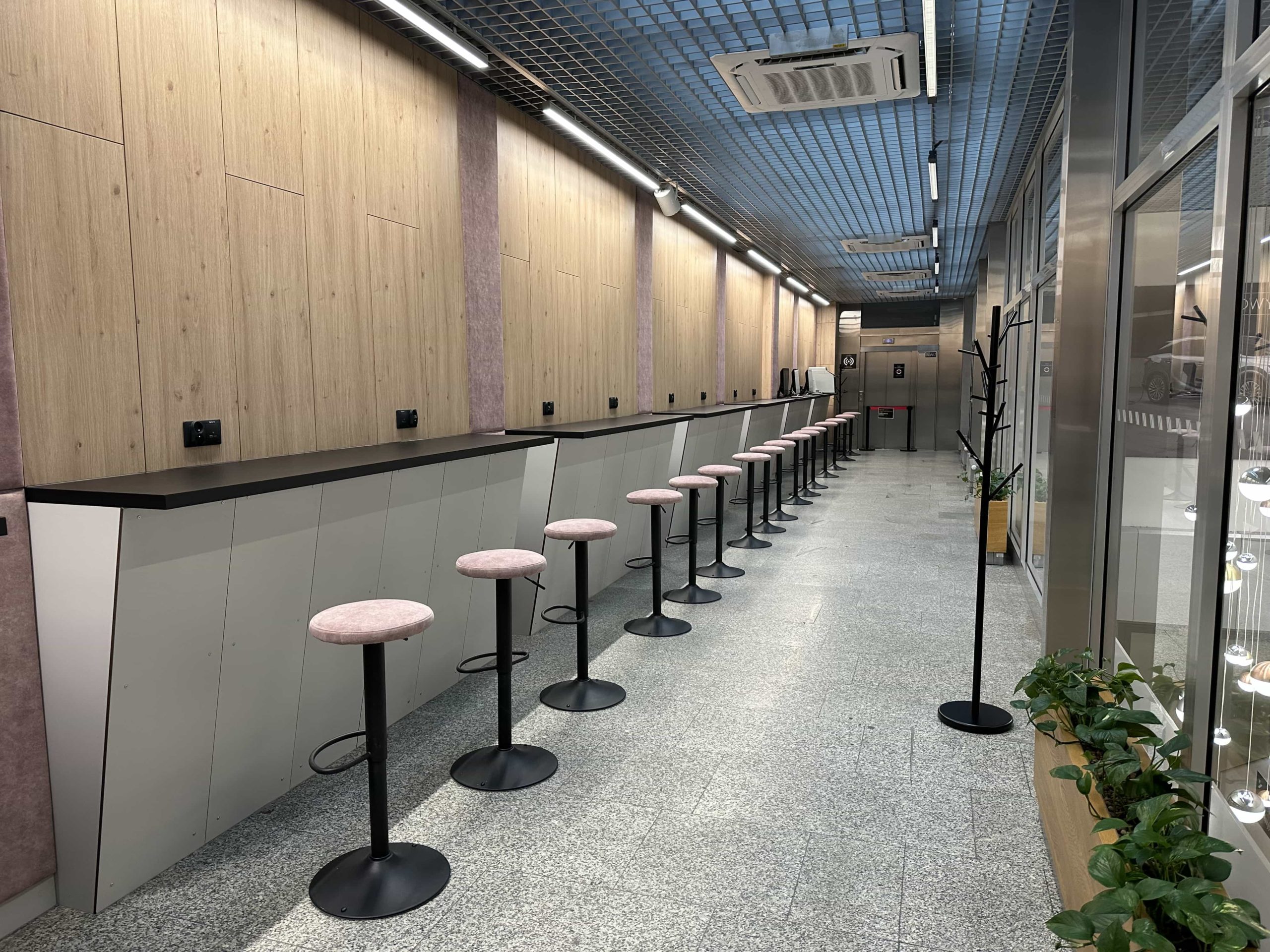 A long line of bar stools along a raised workstation area