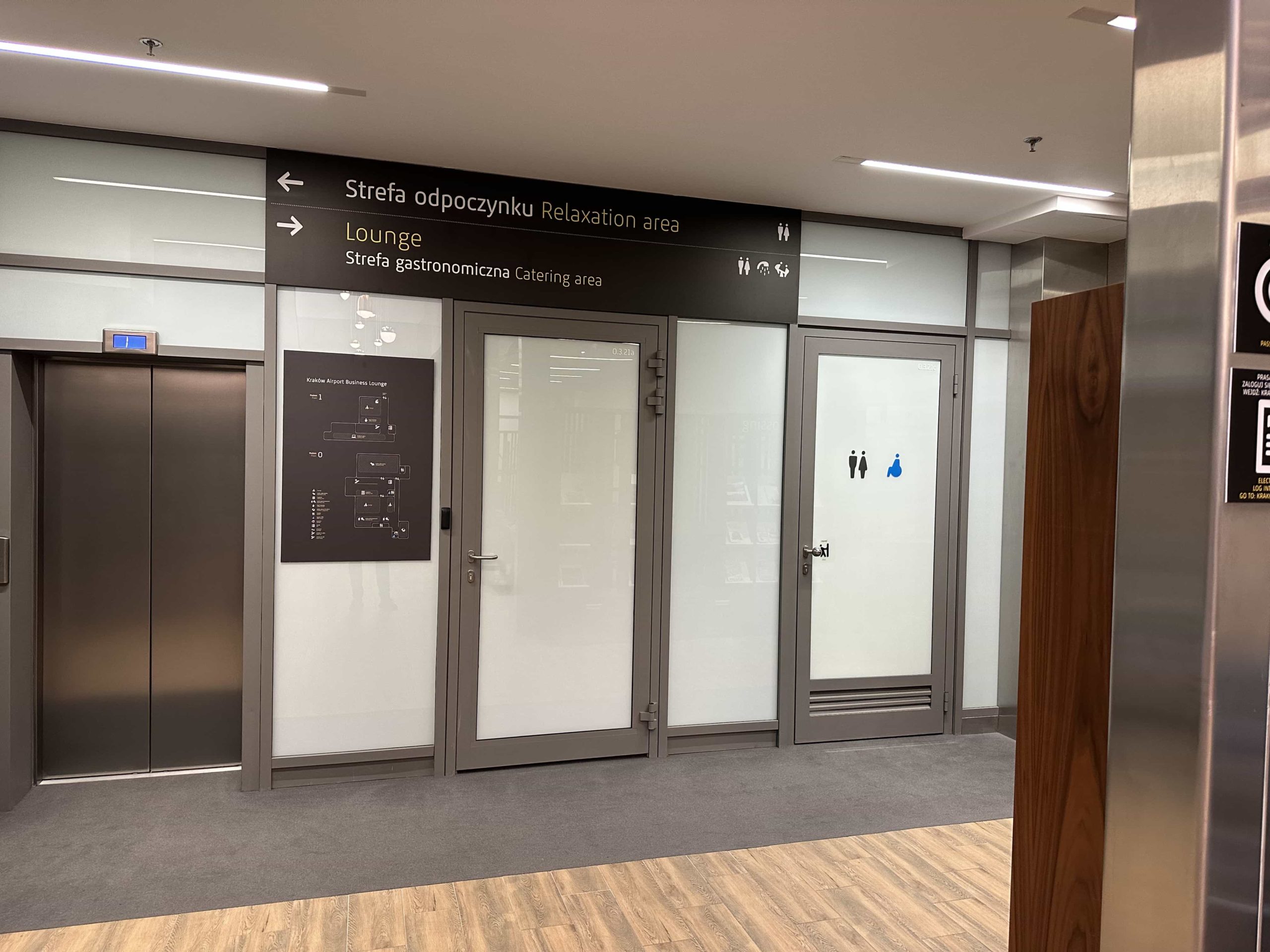 Nondescript doorways, and an elevator, with signage above directing to a Relaxation Area and Lounge