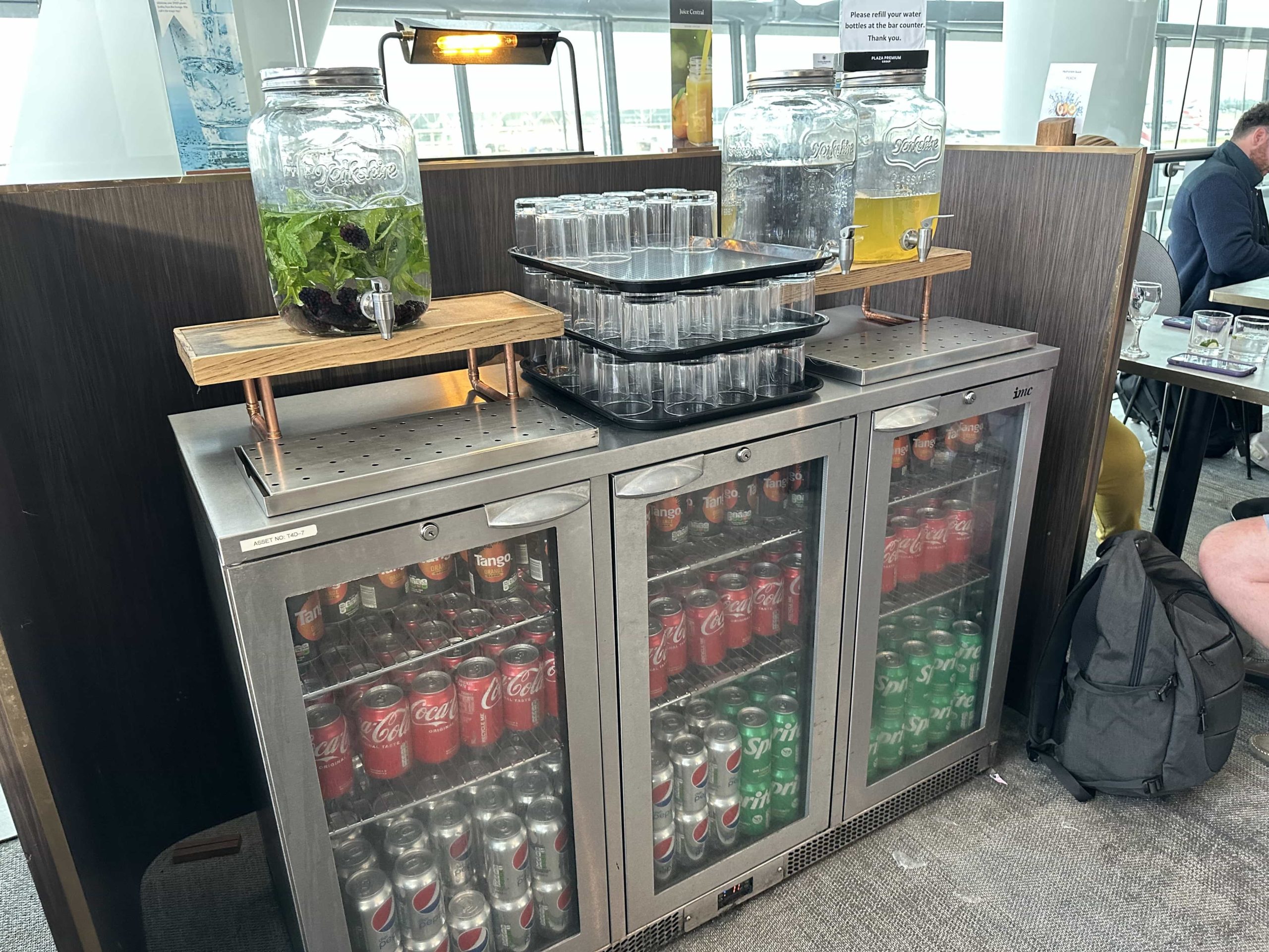 A drinks fridge with Tango, Coca-Cola, Pepsi, and Sprite, with water dispensers on top