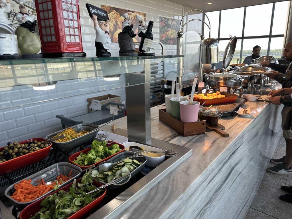 A selection of salad items and hot dishes at an airport lounge buffet