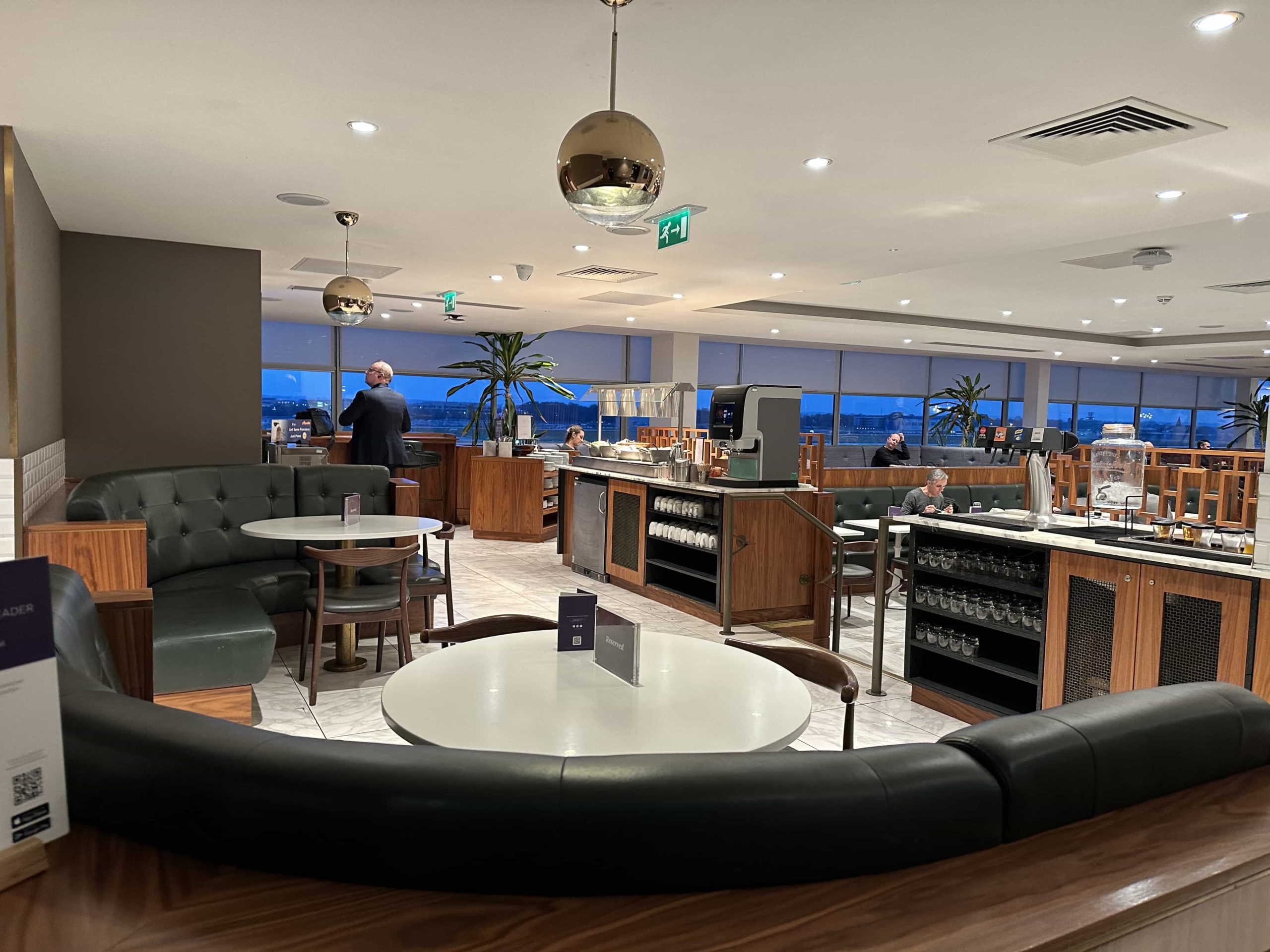 Leather corner booths with dining tables, next to a buffet setup