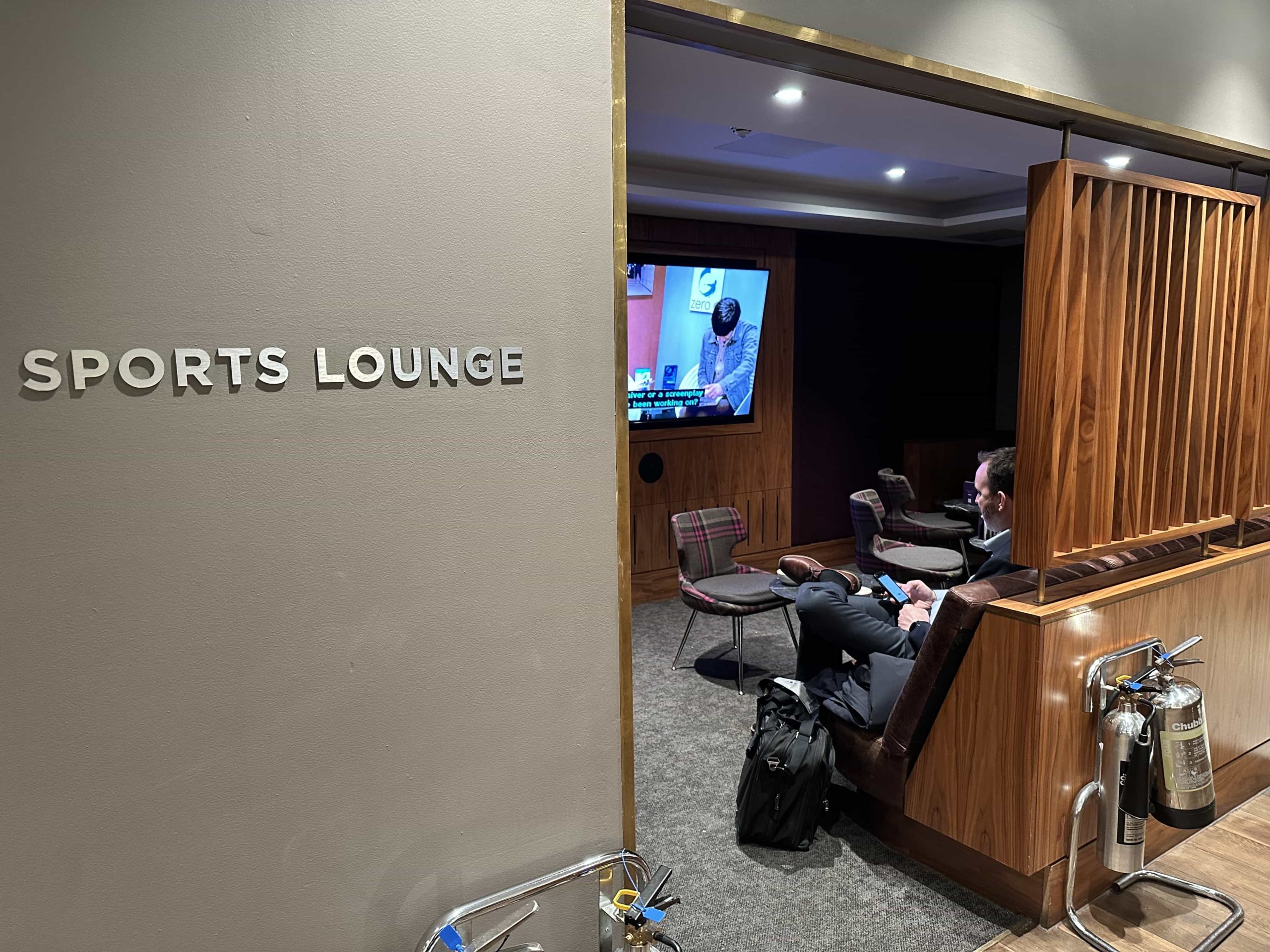 A 'sports lounge' room with seating and a wall-mounted TV