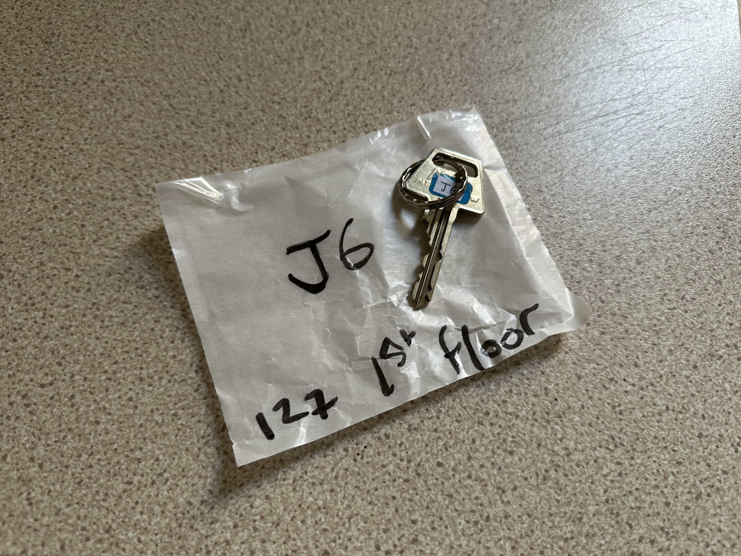 A packet marked with room details, and a key lying on top