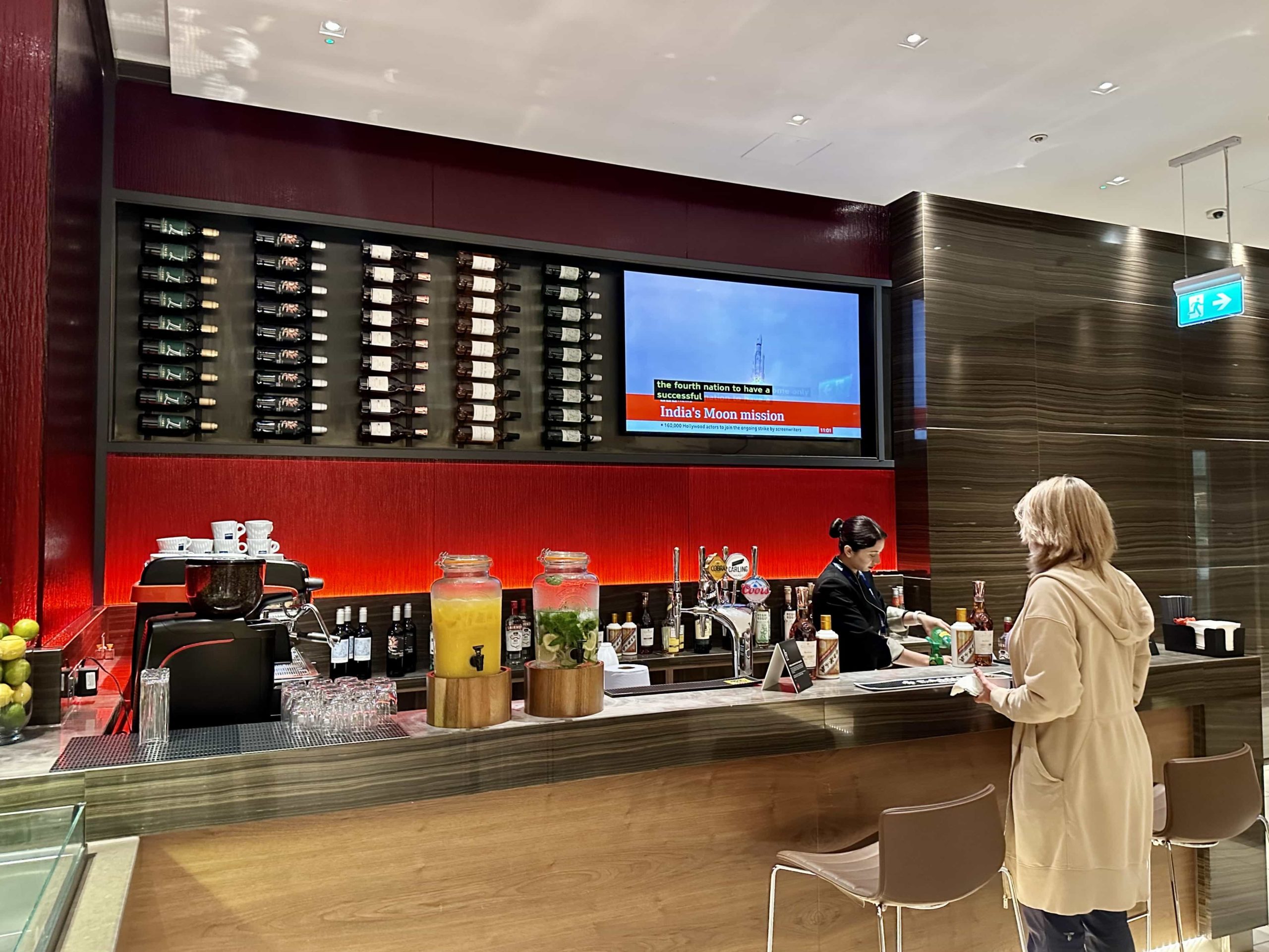 A staffed bar area, with a range of wines displayed on the wall behind