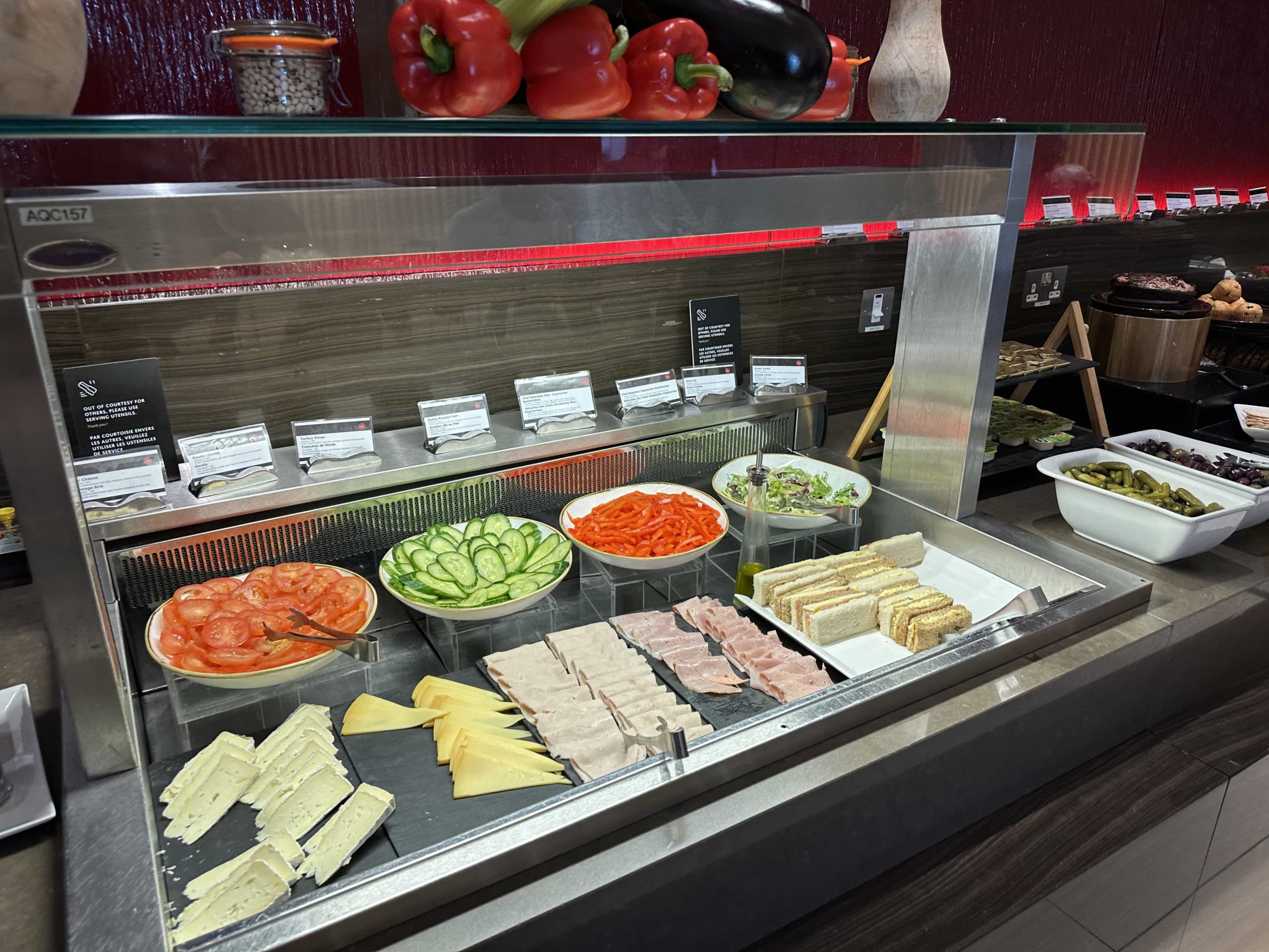 Salad items, cold cut meats, and cheeses within a buffet station