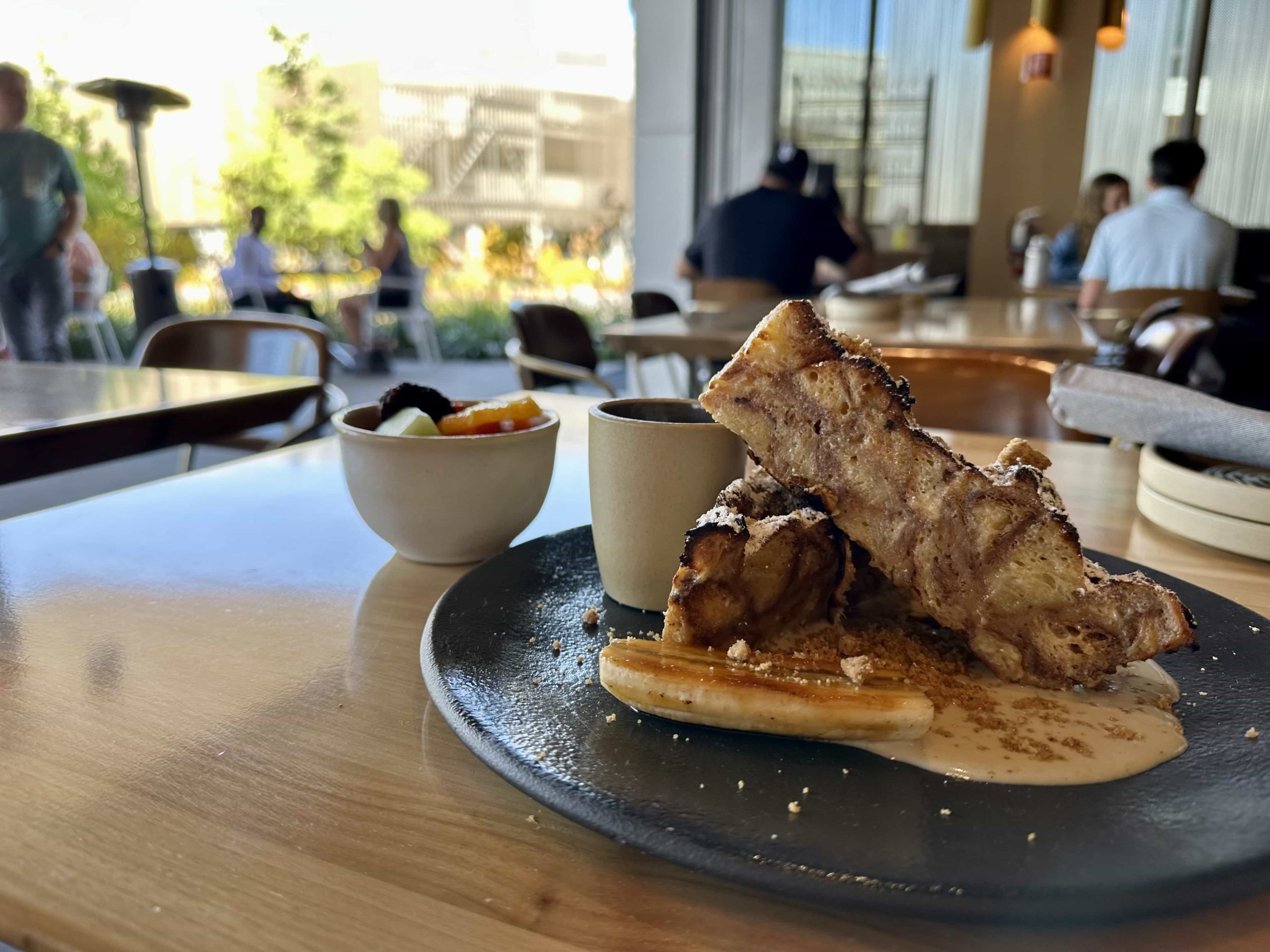 An elaborate example of French toast, with a side of fruit