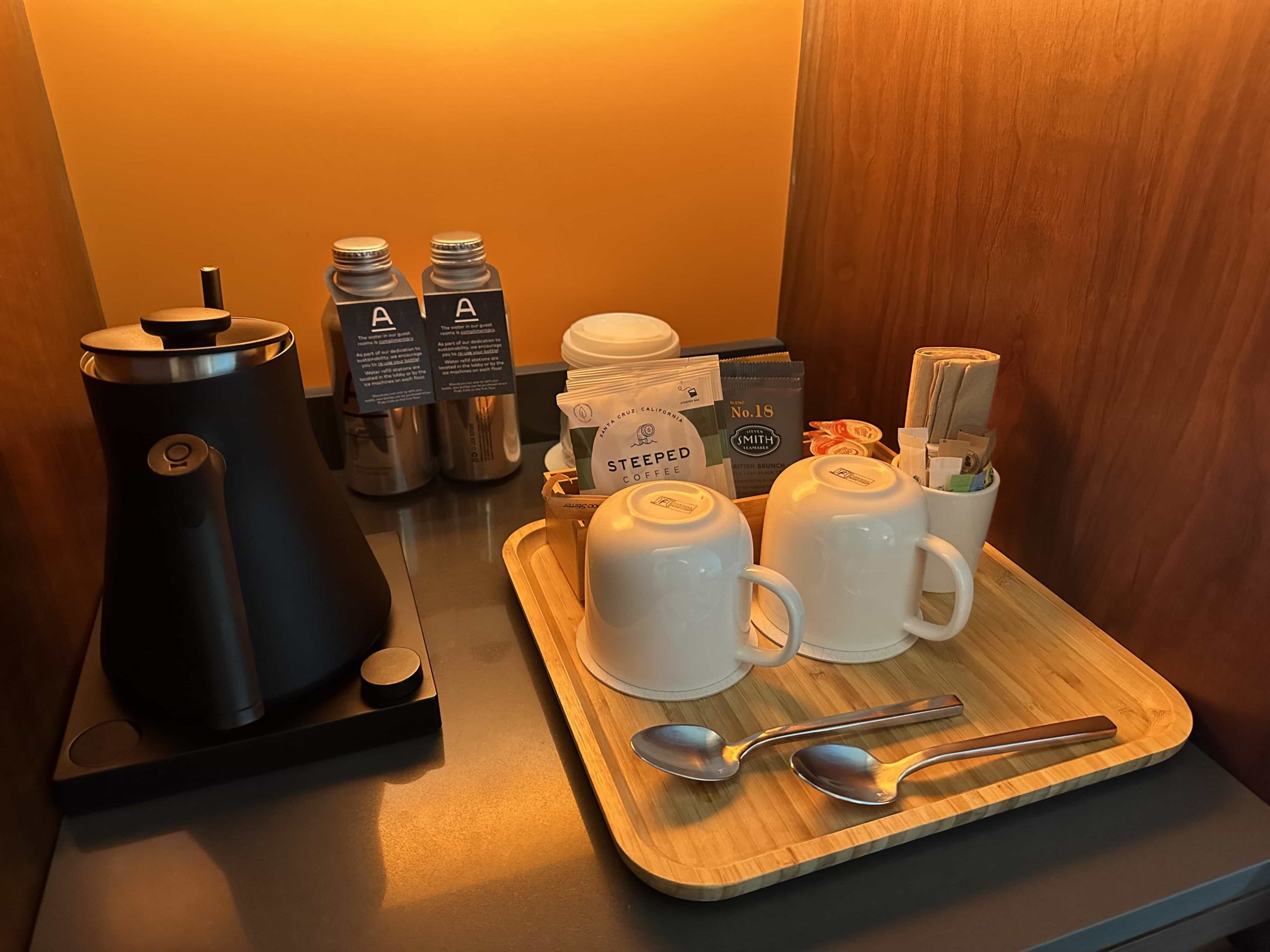 A kettle, coffee and tea packets, mugs, and aluminium water bottles