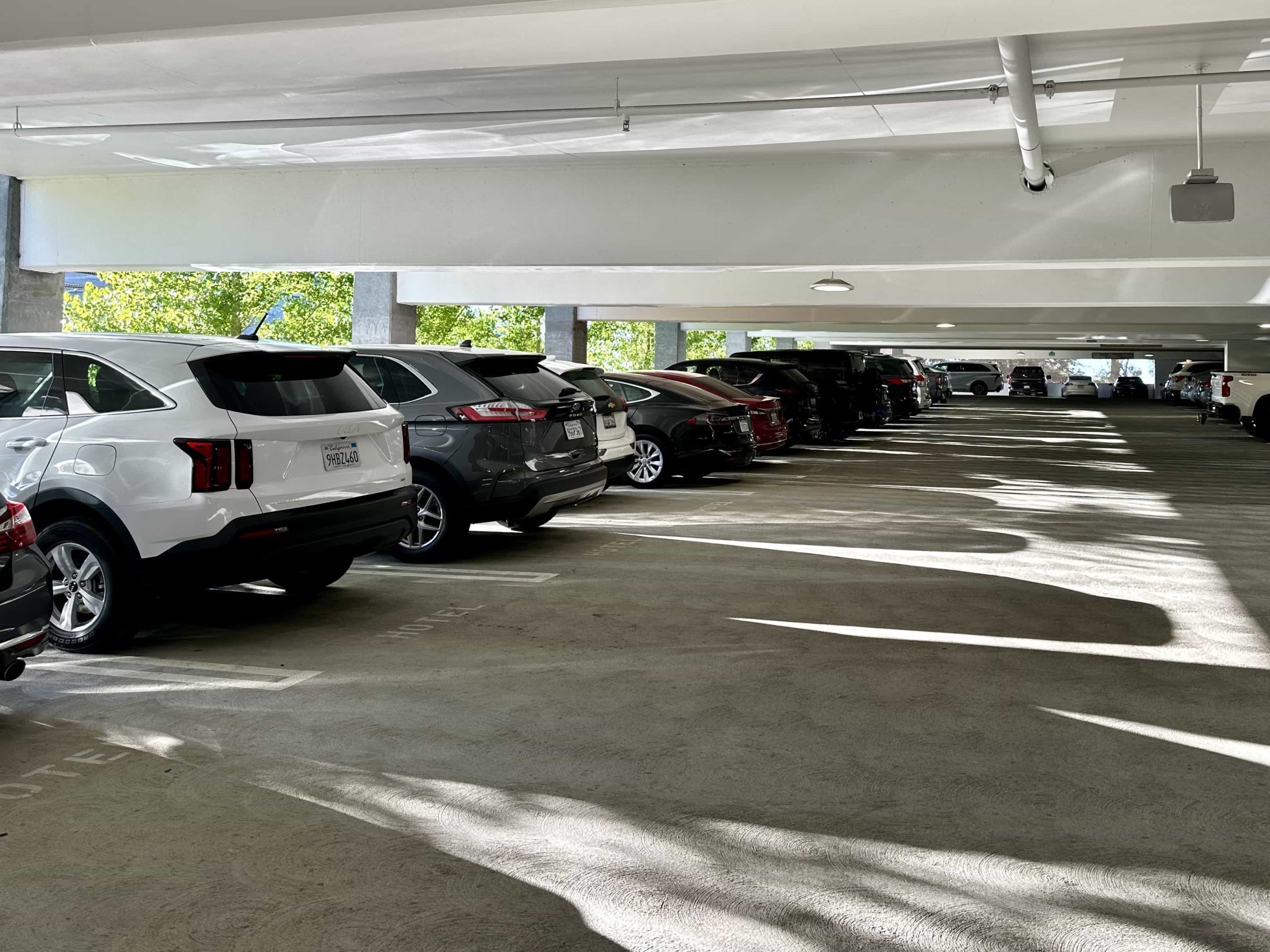 Cars parked within the ground floor of a large parking garage