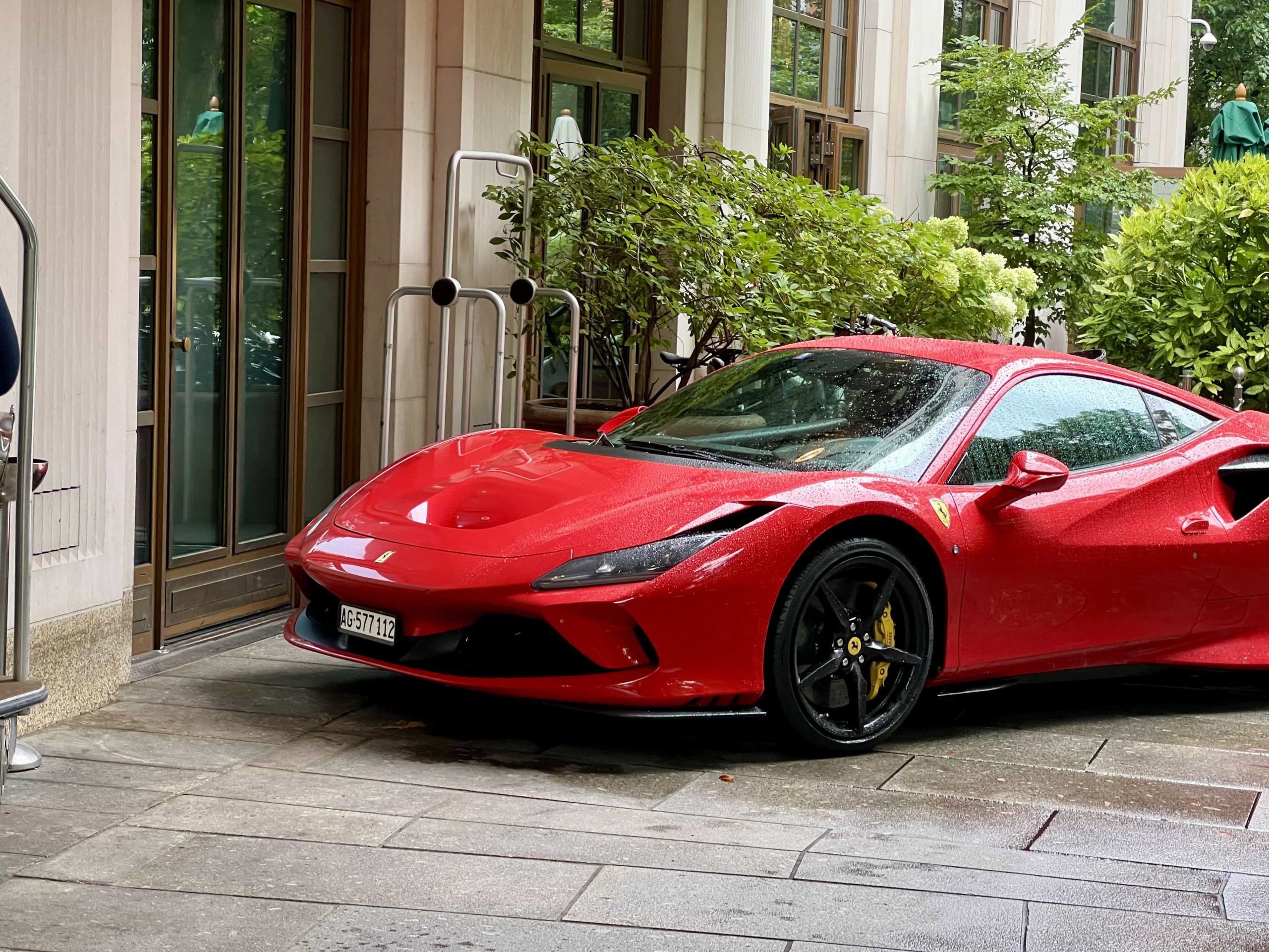 A Ferrari F8 Tributo parked next to the entrance to The Charles Hotel